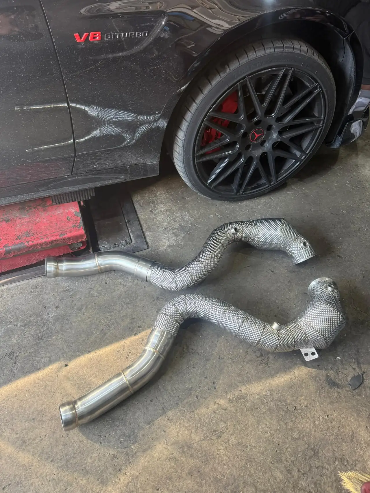 Performance car and fabricated exhaust hardware inside the workshop